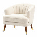 Sillón tapizado en chenilla crema con patas de madera y detalles dorados